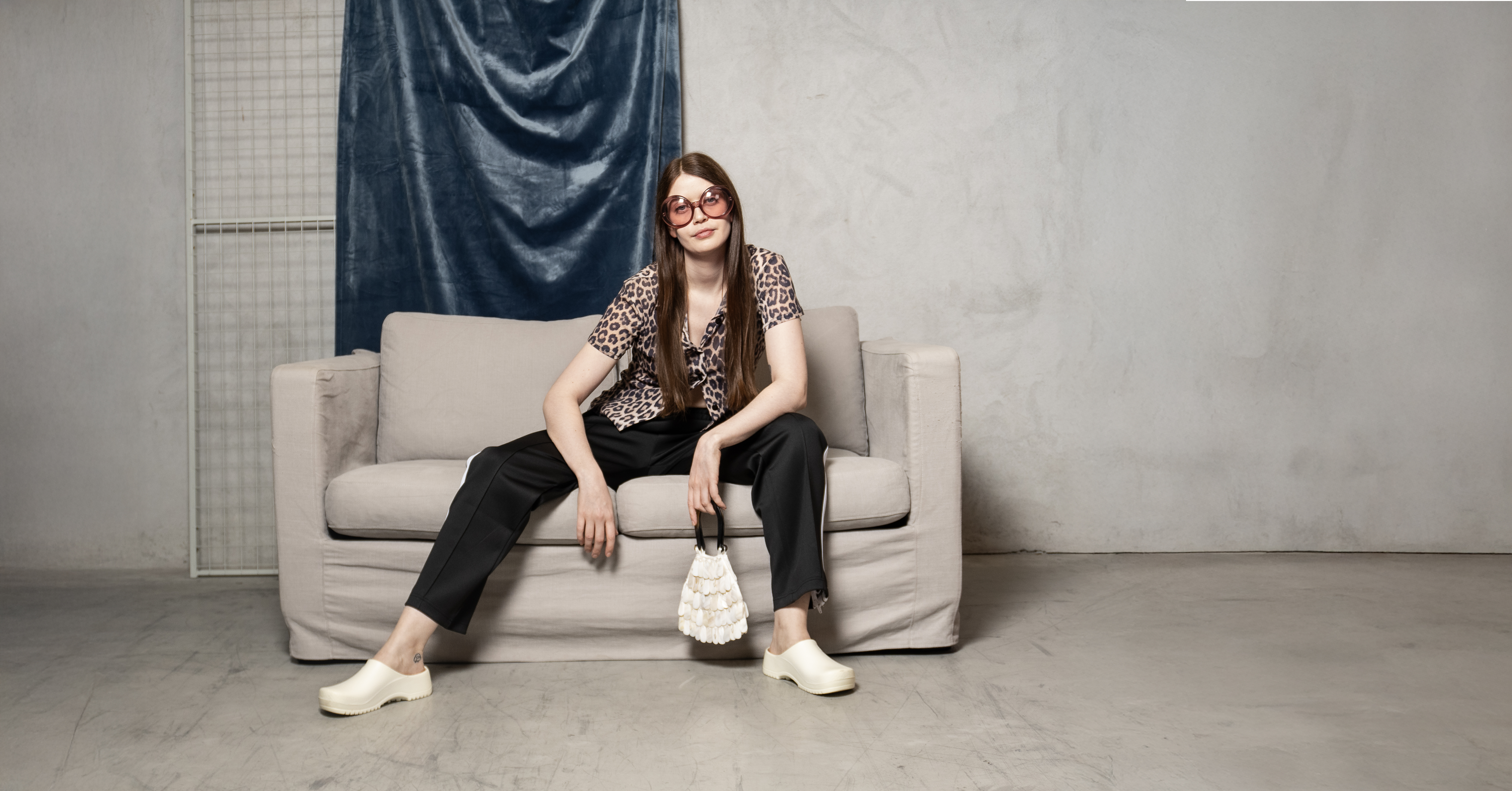 dame på sofa med veske i hånda